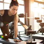 Fitness girl lifting dumbbell in the morning.