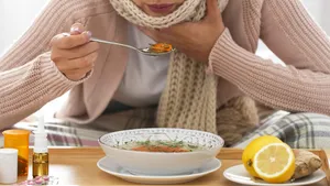 Sick young woman eating soup to cure flu at home, closeup