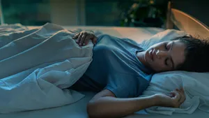 Vrouw ligt te slapen in koele slaapkamer voor een betere nachtrust.