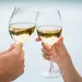 Twee glazen proosten met witte wijn