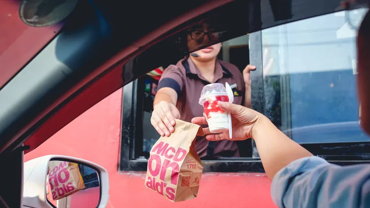 Bangkok, Thailand - Mar 4, 2017: customer receiving hamburger and ice cream after order and buy it from McDonald's drive thru service