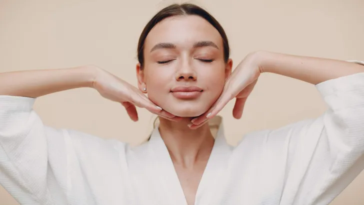 Young woman doing face building facial gymnastics self massage and rejuvenating exercises