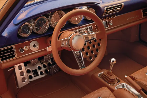 Interieur van de Louis Vuitton x Singer Porsche 911 met blauw dashboard, leren stuur en handgeschakelde versnellingsbak.