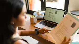 Rear view of a young woman working on her resume