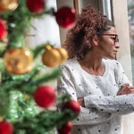 Pensive young black woman celebrating Christmas alone