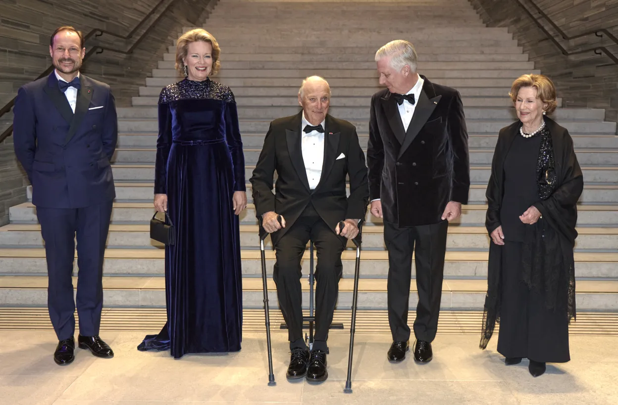 Koning Harald van Noorwegen met een zitje en krukken bij het staatsbezoek van België aan Noorwegen.