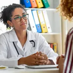 Female patient speaking with her paediatrician in a doctors office