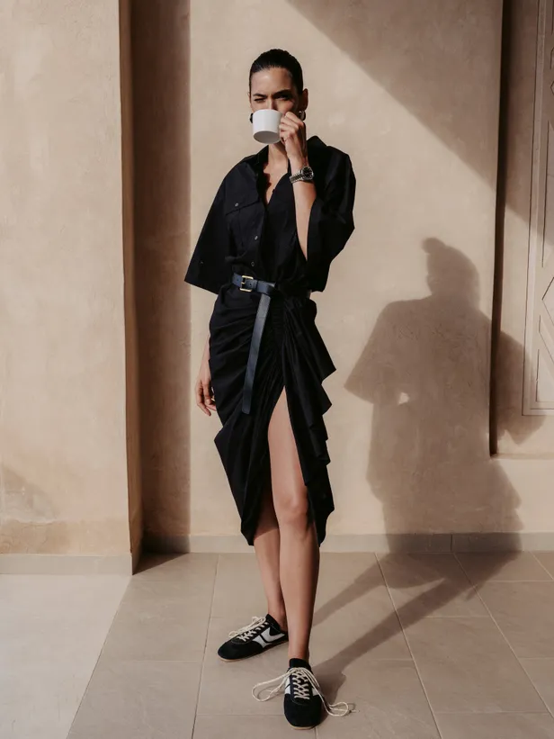 Katoenen jurk en leren riem: Michael Kors Collection | Zilveren oorbellen: Ami Paris | Horloge: 'Seamaster' Omgea | Sneakers: Dries van Noten 