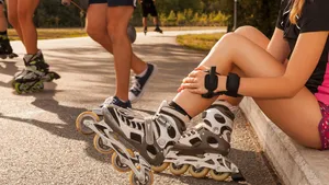 woman holds her shin while having a break sitting on curb