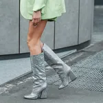 Street style, woman wearing neon green cardigan and shorts, matching neon green blazer jacket and heels knees boots.