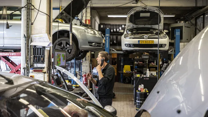Monteurs werken aan verschillende auto's op hefbruggen in een garage in Enschede