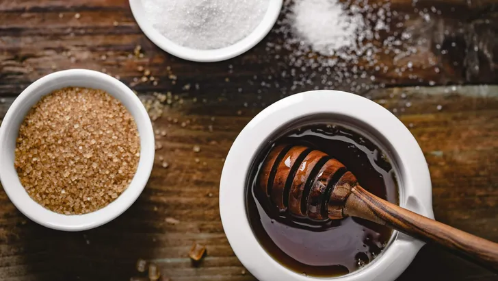 different kinds of sugar and maple syrup on a background