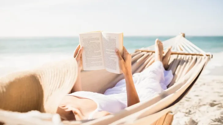 Woman reading book in hammock