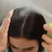 Vrouw spuit droogshampoo op haar