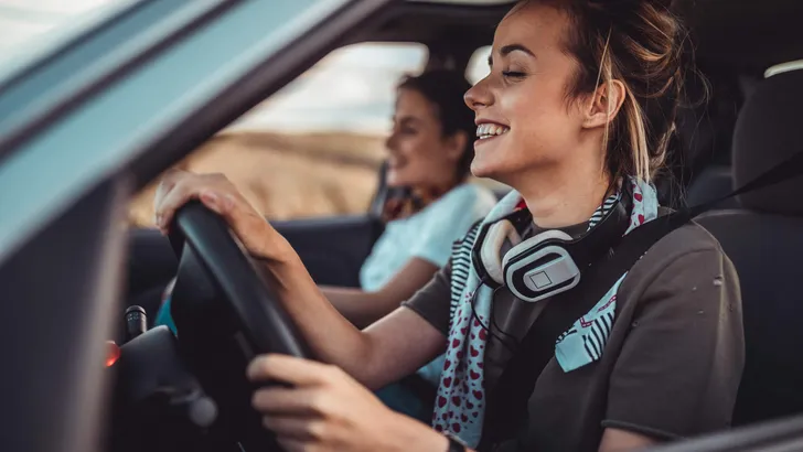 Twin sisters driving car and enjoying road trip