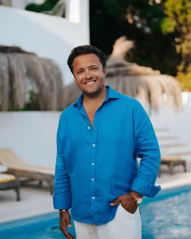 Timothy poseert in een blauw overhemd bij het zwembad van zijn B&B op Ibiza voor B&B Vol Liefde 2026.