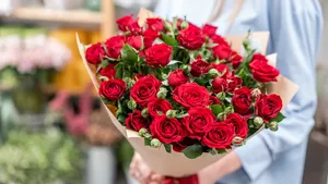 Vrouw krijgt een mooi boeket rode rozen voor Valentijn.