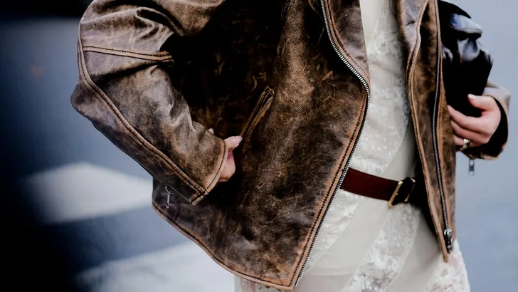 Asymmetrische zwarte top met kant van H&M, zichtbaar onder een trui voor een speelse twist