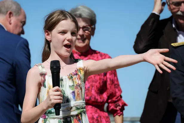 Foto van prinses Gabriella met microfoon bij de inhuldiging van de naar haar vernoemde mediatheek, juli 2025.