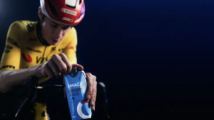 Wielrenner Jonas Vingegaard drinkt uit flesje na inspannende rit, met helm op, als onderdeel van zijn herstelstrategie."