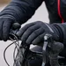 Fietser met dikke winterhandschoenen op een racefiets, handen op het stuur tijdens een koude rit