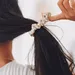 Vrouw haalt haar elastiek uit haar haren.
