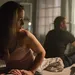 Vrouw zit op bed met rug naar man toe na break-up - broer