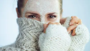elegant woman with white facial mask hiding behind clothes