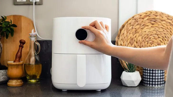 Woman cooking with modern Air fryer