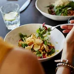 Woman having food at restaurant table