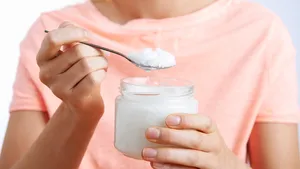 Close-up van een vrouw met een lepel kokosolie.