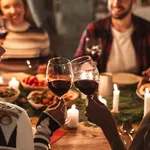 Photo of nice joyful people drinking wine and having Christmas dinner