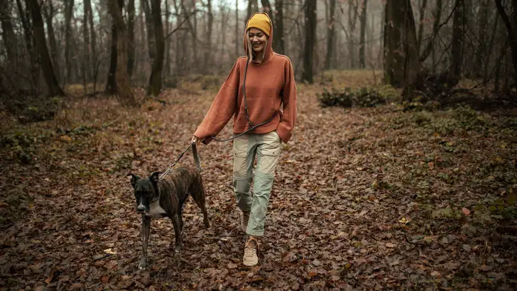 Young Caucasian woman walking her dog in nature