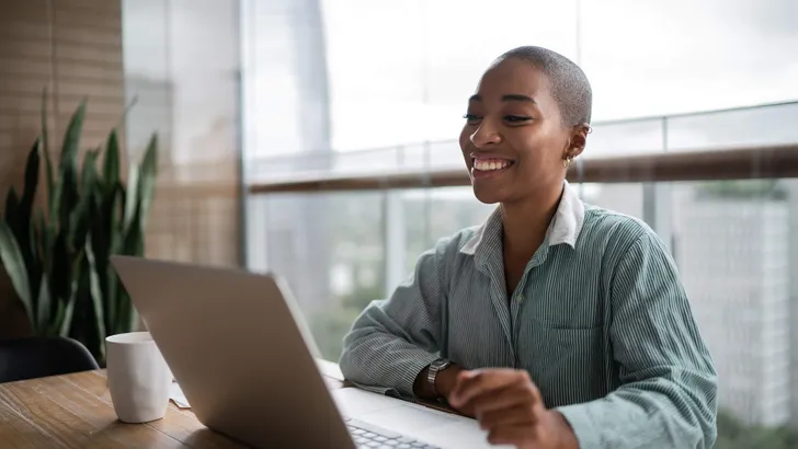 Young woman working and doing a virtual business meeting on laptop at home