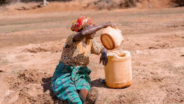 African woman fetching water in dry area
