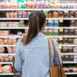 Unrecognizable woman marvels at grocery bread selection