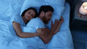 Lovely couple sleeping together in bed at night, top view