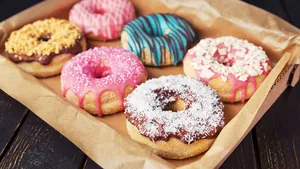 A box with fresh homemade donuts with icing.