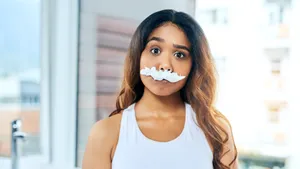 Cropped shot of a young woman posing with a fake mustache made from shaving cream