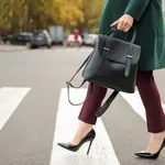 Beautiful fashionable woman crossing road