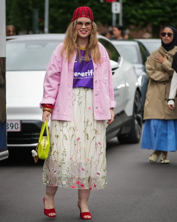 Een vrouw in voetbal-jersey met roze spijkerjack tijdens de OperaSport show tijdens de Copenhaagse Fashion Week 2025.