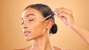 Vrouw brengt skincare aan op huid.