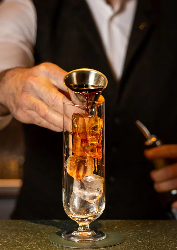 Een cocktail bereid door een barman in Specht Bar & Lounge