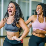 Middle-aged women enjoying a joyful dance class, candidly expressing their active lifestyle through Zumba with friends, generative ai