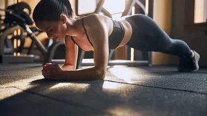 Relaxed sporty woman exercising core in gym