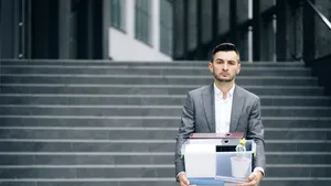 Ter illustratie: ontslagen man loopt met zijn spullen naar buiten