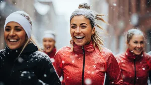 Smiling portrait of a young and diverse group of female friends jogging during the winter and snow in the city