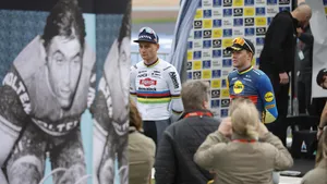 van der poel en pedersen bij een grote poster van eddy merckx