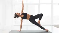 Woman doing side plank exercise at modern studio