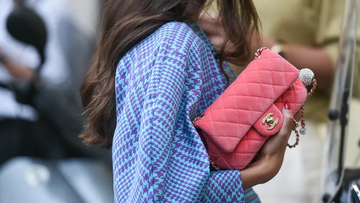 Weekendtips voor Pasen 2025. – Streetstyle-foto van vrouw in blauwe blouse met roze Chanel-tas.